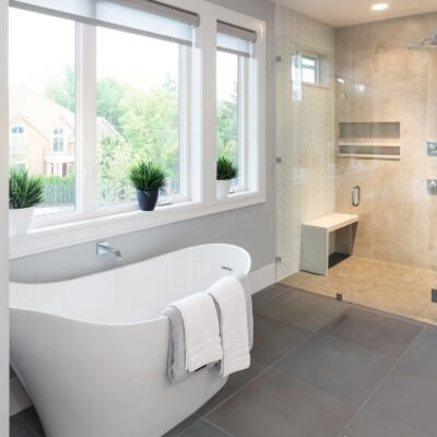 White bathtub in front of windows