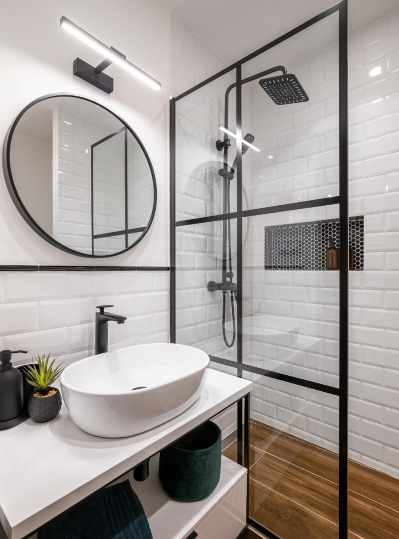 Modern bathroom sink and shower with black accents